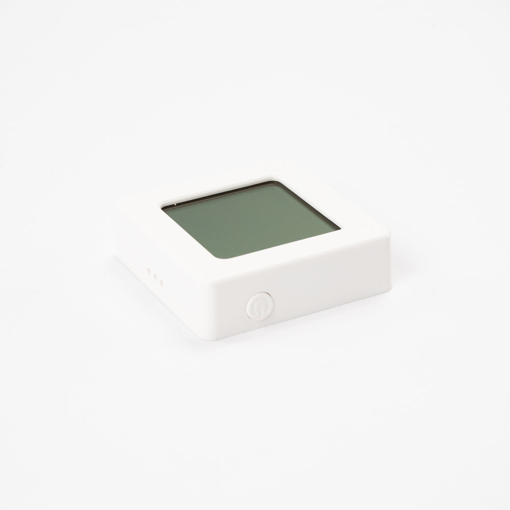 Hygrometer von urbanhive von der Seite – kompaktes weißes Gehäuse mit Ein-/Aus-Taste.